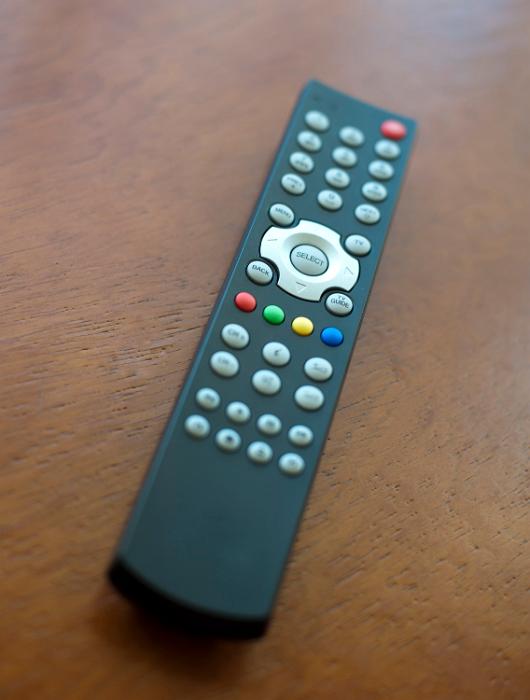 Television remote control on wooden table
